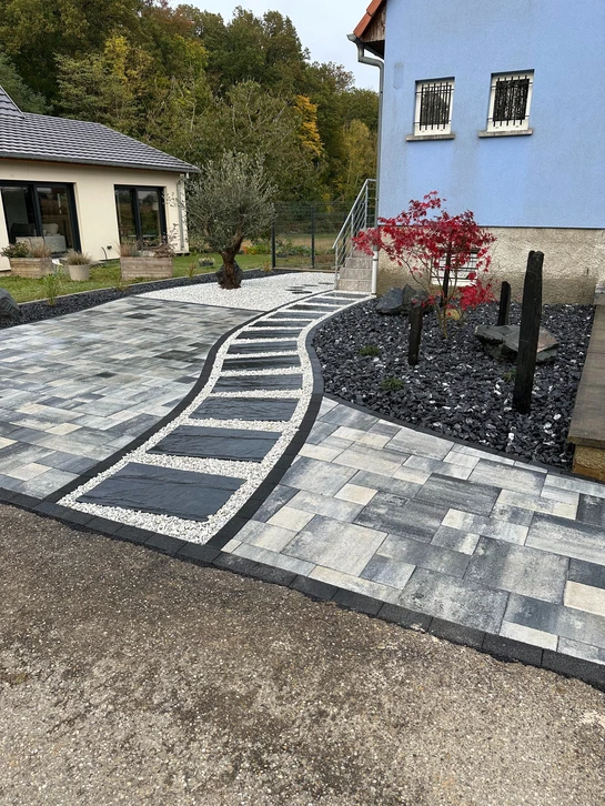 Scène extérieure nocturne montrant une plateforme surélevée avec surface pavée intégrant des spots lumineux LED encastrés