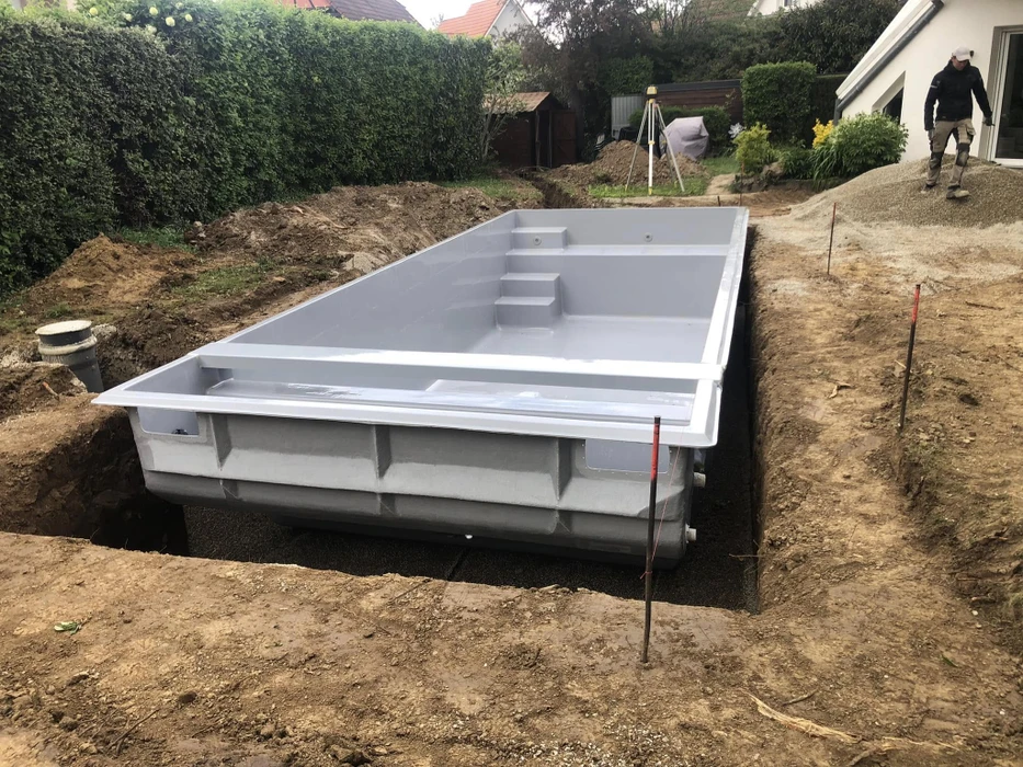 Piscine privée illuminée la nuit dans un jardin tropical luxueux, entourée de végétation dense et palmiers