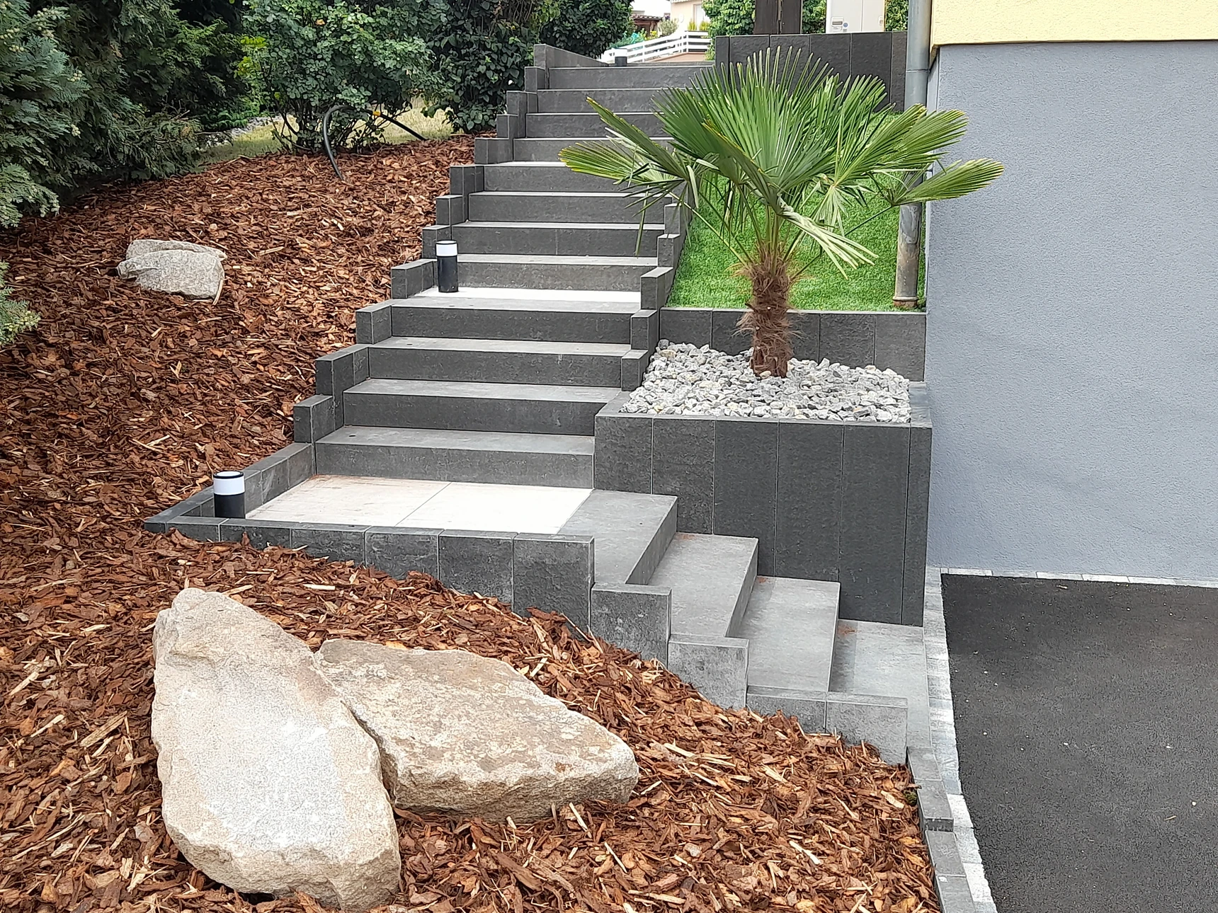 Aménagement paysager extérieur nocturne avec terrasse en dalles de pierre naturelle claire